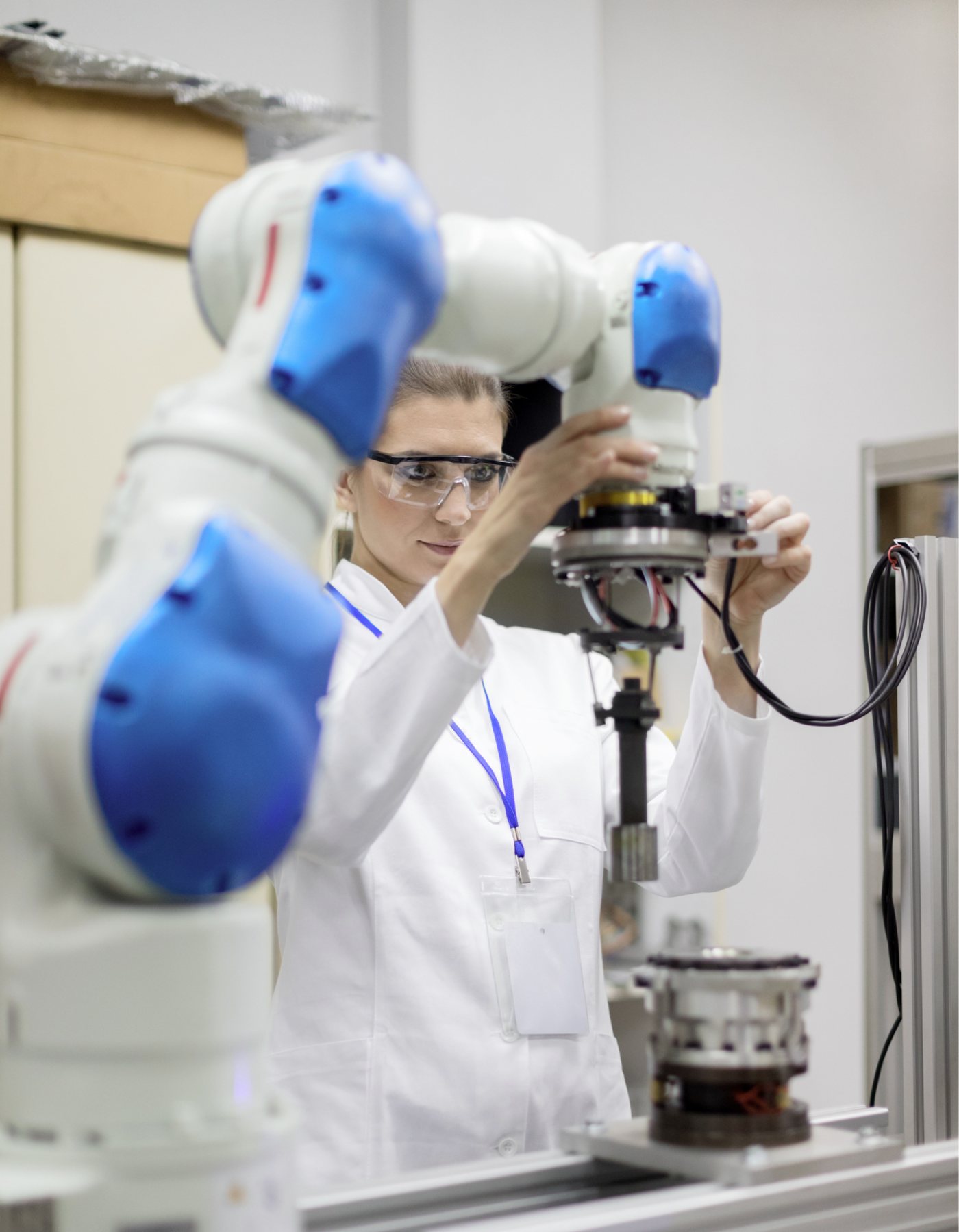 Especialista técnica operando un brazo robótico colaborativo en laboratorio industrial Innobot